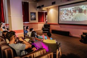 uma multidão de pessoas assistindo um filme em um grande ecrã em YHA Sydney Central em Sydney