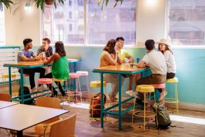 grupa ludzi siedzących przy stolikach w restauracji w obiekcie YHA Sydney Central w mieście Sydney