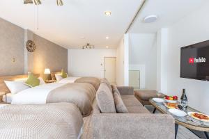 - un salon avec deux lits et un canapé dans l'établissement Precious House Nipponbashi, à Osaka