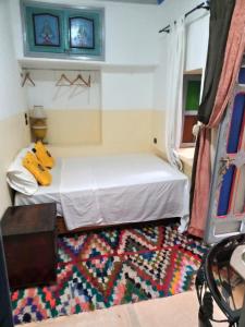 mały pokój z łóżkiem i dywanem w obiekcie RIAD DAR WINK w Marakeszu