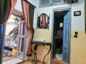 Pokój z dwoma niebieskimi drzwiami i stołem w obiekcie RIAD DAR WINK w Marakeszu