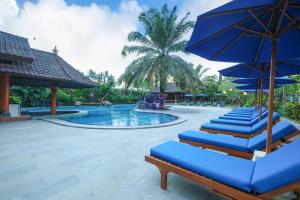 a pool with blue lounge chairs and umbrellas at Bhuwana Ubud Hotel and Farming in Ubud