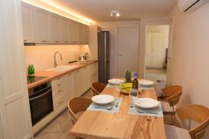 a kitchen with a wooden table and chairs in it at Sea Senses Andros - A Beachfront Retreat in Gavrio
