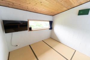 ニセコ町にあるNiseko にくやどやの小さな客室で、テレビ、窓が備わります。