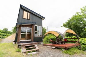 a tiny house with a gazebo and a bench at Niseko Nikuyadoya in Niseko