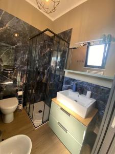 uma casa de banho com um chuveiro, um lavatório e um WC. em Appartamento a 200 mt dal mare em Rimini