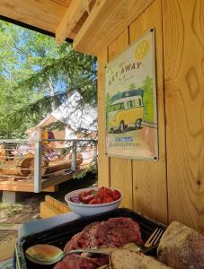 a table with a tray of meat and a plate of food at Glamping Stola- Šepot kvetov in Štôla