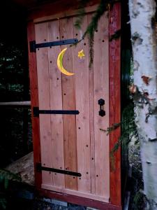 uma porta de madeira com uma lua e uma estrela em Glamping Stola- Šepot kvetov em Stôla