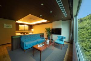 a living room with a blue couch and a table at Grand Blissen Hotel Jozankei in Jozankei
