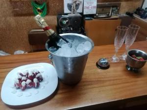 a bottle of wine in a bucket with ice and a plate at HOTEL ALEXANDROS in Loutraki