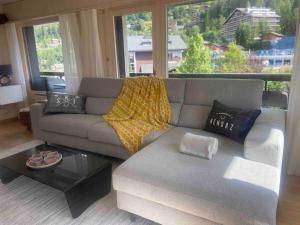 a living room with a couch and a large window at Clair Vue A3 near Télécabine by Jolidi in Nendaz