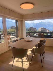 a dining room with a table and chairs and a large window at Clair Vue A3 near Télécabine by Jolidi in Nendaz