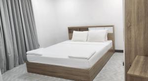 Una cama con sábanas blancas y almohadas en una habitación. en kids Heaven Villa, en Koh Samui 