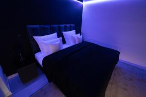 a bedroom with a black bed with white pillows at High Class Suites Mazuria in Mrągowo