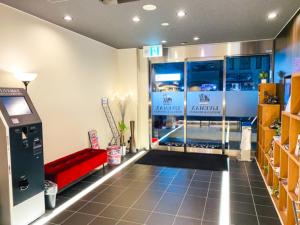 a room with a red couch in a store at HOTEL LiVEMAX Shinsaibashi East in Osaka