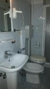 a white bathroom with a toilet and a sink at Hotel Chopin in Milan