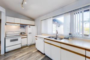 a kitchen with white appliances and a window at The Gardenhouse Cottage One in Wasaga Beach