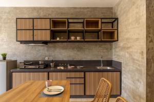 a kitchen with wooden cabinets and a wooden table and chairs at Cove Kanaya in Seminyak