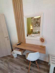 a dressing table with a mirror and a white chair at Christina Apartments in Fourka