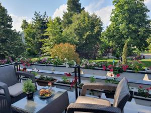 eine Terrasse mit Tischen, Stühlen und Blumen in der Unterkunft Perla Hotel in Pogradec