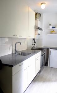 una cocina con armarios blancos y fregadero en Ground Floor Apartment Westerpark, en Ámsterdam
