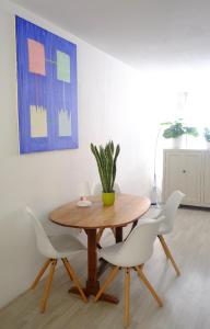 a wooden table with white chairs and a plant on it at Ground Floor Apartment Westerpark in Amsterdam