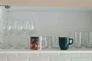 un estante con copas de vino y una taza de café en Apartament 3 camere, doua bai integral pentru familie sau grup, en Cugir