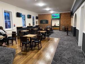 a restaurant with tables and chairs and a screen at Imperial Hotel Bombala in Bombala