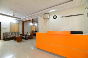 a waiting room with an orange counter and chairs at Hitech Shilparamam Guest House in Hyderabad