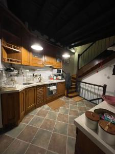uma grande cozinha com armários de madeira e uma escadaria em LITTLE TOWER em Potes