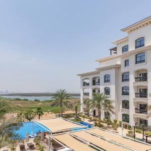 a hotel with a swimming pool and palm trees at Casa Noera, Yas Island 324 in Abu Dhabi