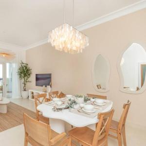 uma sala de jantar com uma mesa branca e cadeiras em Casa Noera, Yas Island 324 em Abu Dhabi
