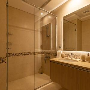 uma casa de banho com uma cabina de duche em vidro e um lavatório. em Casa Noera, Yas Island 324 em Abu Dhabi