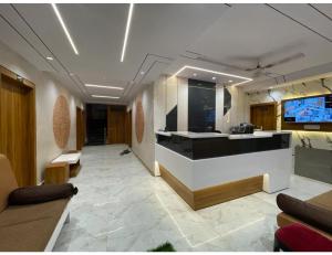 a lobby with a reception desk and a tv in it at Hotel Sukhnath, Somnath in Somnath