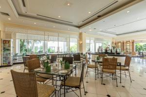 a dining room with tables and chairs and windows at Kantary Bay Hotel And Serviced Apartment Rayong in Rayong