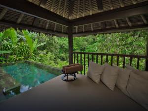 a room with a bed and a swimming pool at Hanging Gardens of Bali in Payangan