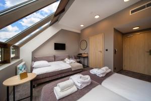 a bedroom with two beds and a large window at Hotel Alexander in Kraków