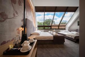 a bedroom with two beds and a large window at Hotel Alexander in Krakow