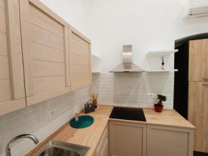 a kitchen with wooden cabinets and a sink at Suites Elifani in Trani