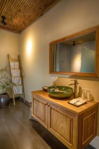 La salle de bains est pourvue d'un lavabo et d'un miroir sur un comptoir. dans l'établissement HỒ ĐÁ CỔ THIÊN LONG Hoa Le, à Hòa Bình