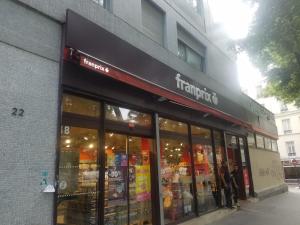 un negozio di fronte a un edificio con persone in piedi fuori di Studio Metro GALLIENI a Bagnolet