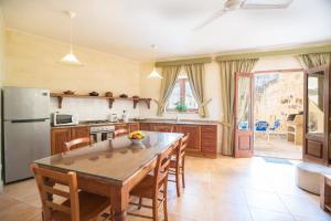 a kitchen with a table and chairs and a refrigerator at Ta' Gianni in Xewkija