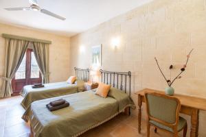 a bedroom with two beds and a table and chairs at Ta' Gianni in Xewkija