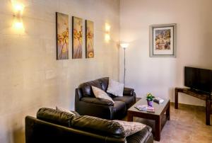 sala de estar con sofá y TV en Karmnu Holiday Farmhouse, en Għasri