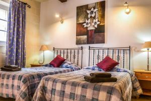 dos camas sentadas una al lado de la otra en una habitación en Karmnu Holiday Farmhouse, en Għasri