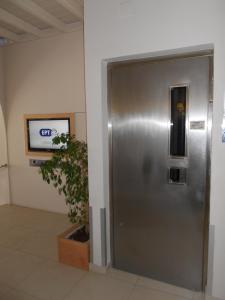a metal elevator in a room with a tv at Hotel Lito in Tinos Town