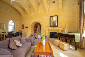 a living room with a couch and a piano at Ghar Ilma IV Holiday Home in Santa Luċija