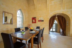 a dining room with a wooden table and chairs at Ghar Ilma IV Holiday Home in Santa Luċija