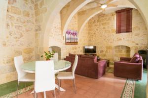 a living room with a table and chairs and a couch at Kikka Holiday Home in Xagħra