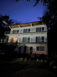 Un grand bâtiment blanc avec balcon est disponible la nuit. dans l'établissement Orsova Gratca 164, à Orşova